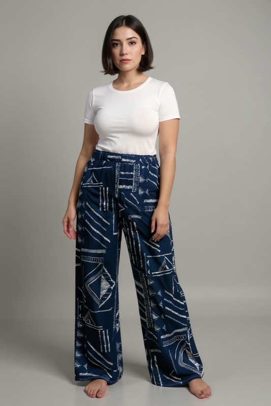 Woman wearing a white top and blue patterned pants on a gray background