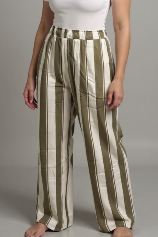 Woman wearing a white top and striped pants on a gray background
