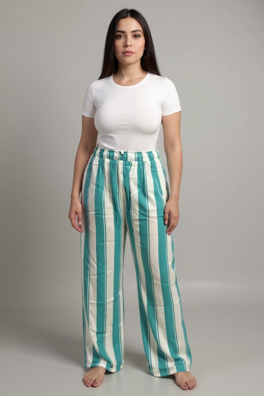 Woman wearing a white t-shirt and green and white striped pants on a gray background